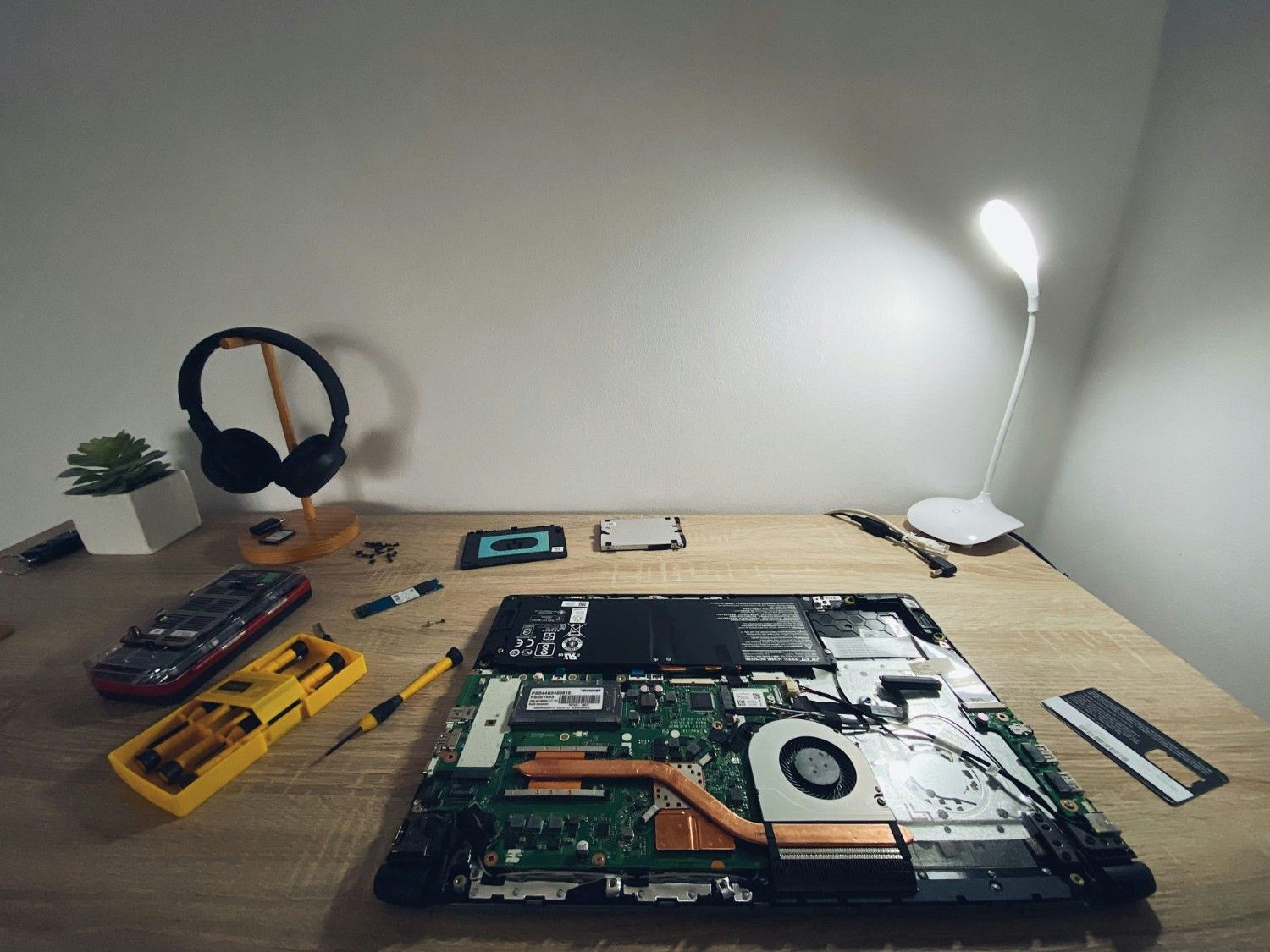 une table avec un ordinateur portable et un casque audio dessus