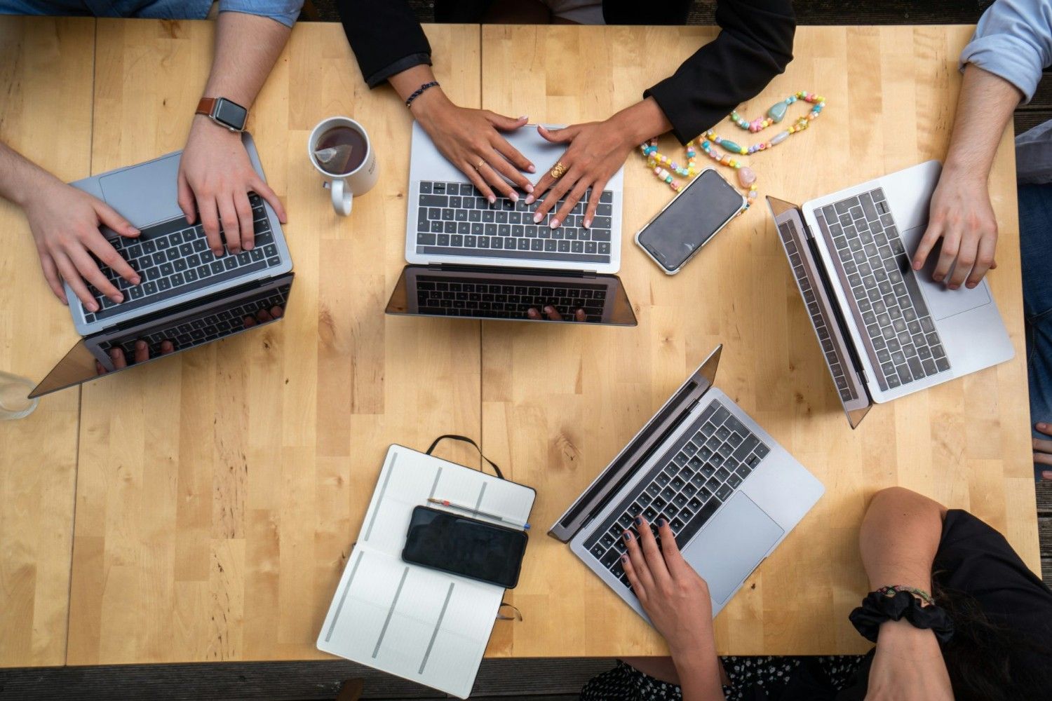 une personne utilisant un MacBook Pro sur une table en bois marron