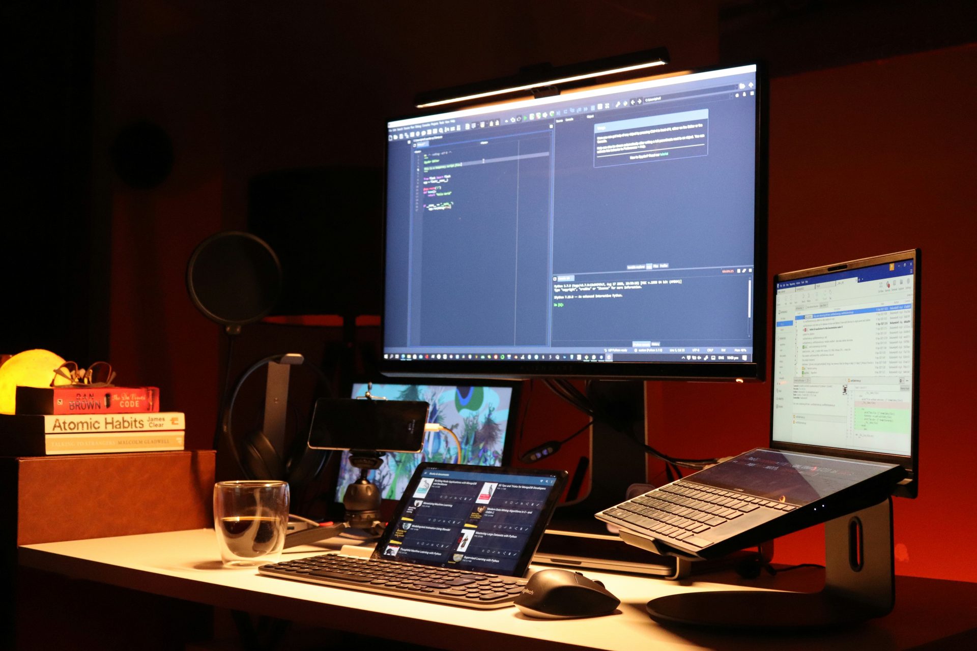 Un écran plat noir d'ordinateur est allumé à côté d'un ordinateur portable noir.