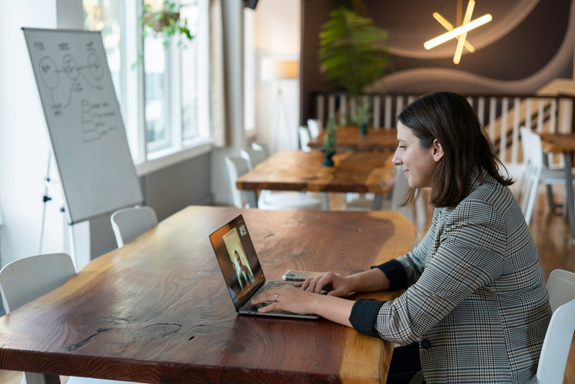 femme en chemise à manches longues rayée grise et blanche utilisant un MacBook argenté